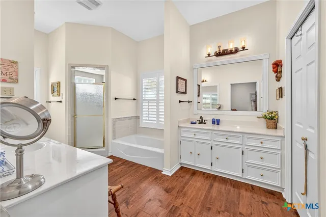a living room with furniture a flat screen tv and a wooden floor