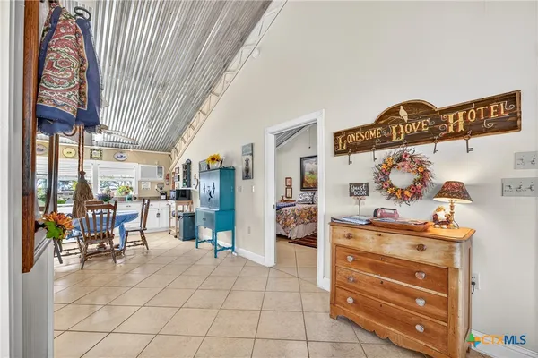 a kitchen with stainless steel appliances kitchen island granite countertop dining table chair and a refrigerator