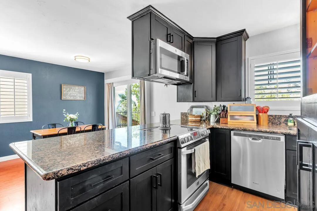 1635 Portola Avenue Spring Valley, CA 91977 - Photo 14 of 54 a kitchen with stainless steel appliances granite countertop a sink stove and microwave