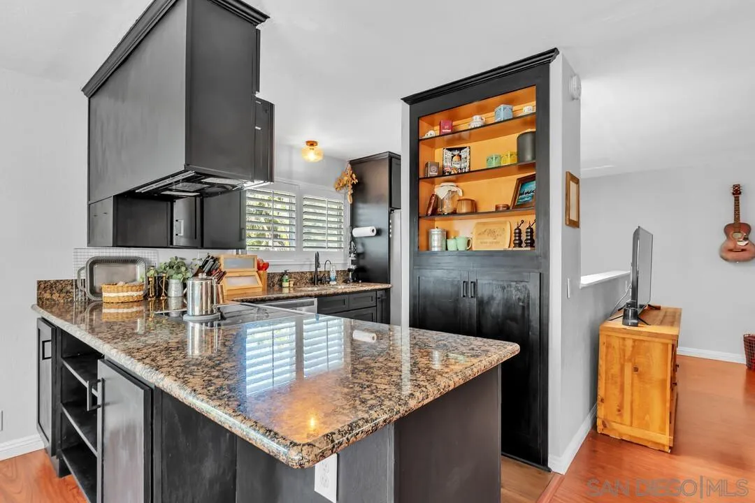 1635 Portola Avenue Spring Valley, CA 91977 - Photo 16 of 54 a kitchen with granite countertop a sink and a wooden floor