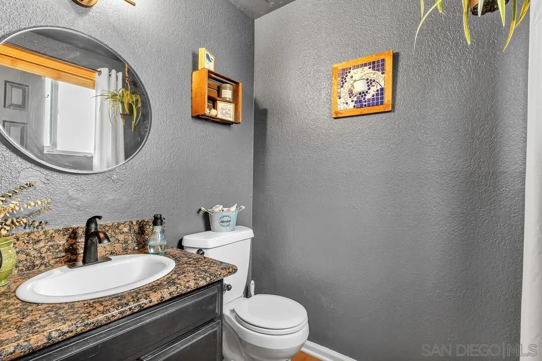 1635 Portola Avenue Spring Valley, CA 91977 - Photo 23 of 54 a bathroom with a toilet a sink and mirror