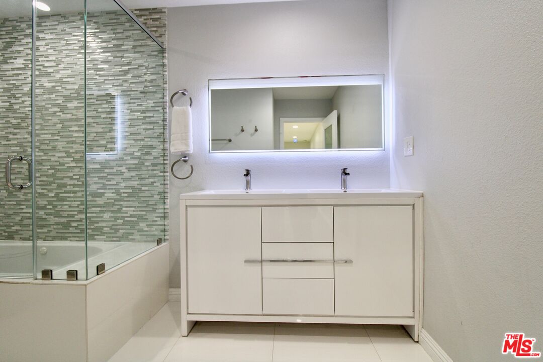 8421 Darby Avenue Northridge, CA 91325 - Photo 13 of 38 a bathroom with a bathtub sink vanity and mirror