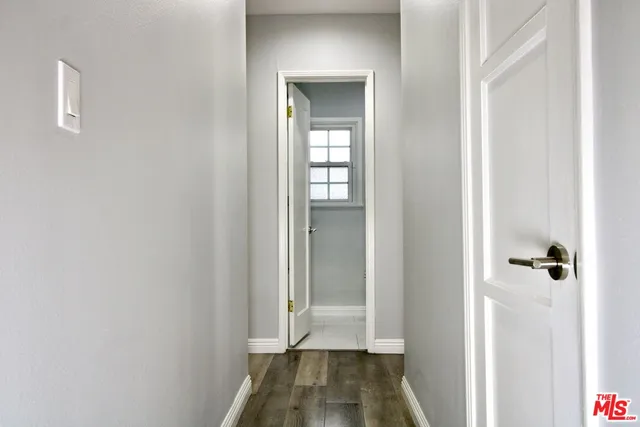 a view of a hallway with wooden floor and closet