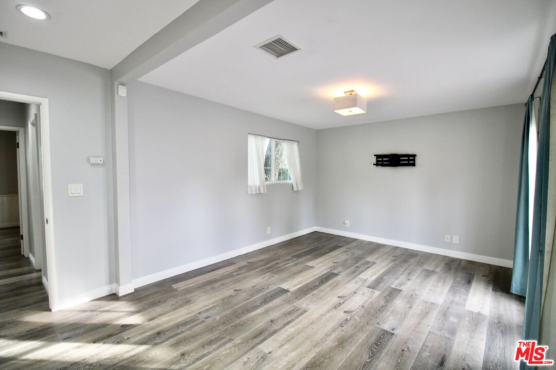8421 Darby Avenue Northridge, CA 91325 - Photo 20 of 38 a view of an empty room with wooden floor and a window