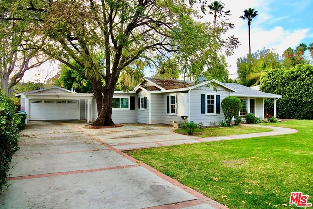 a front view of a house with yard and green space