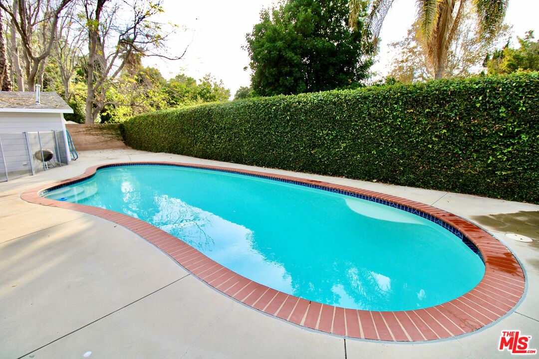8421 Darby Avenue Northridge, CA 91325 - Photo 26 of 38 a view of a swimming pool with a yard and green space