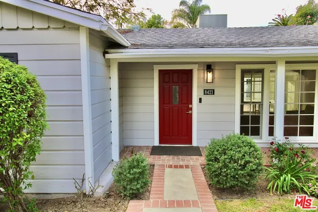 a front view of a house with plants
