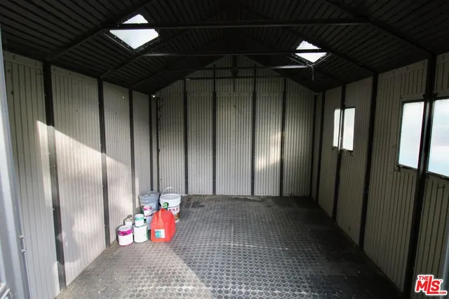 a view of an empty room with wooden floor and windows