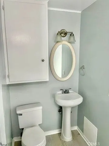a bathroom with a sink toilet and a mirror