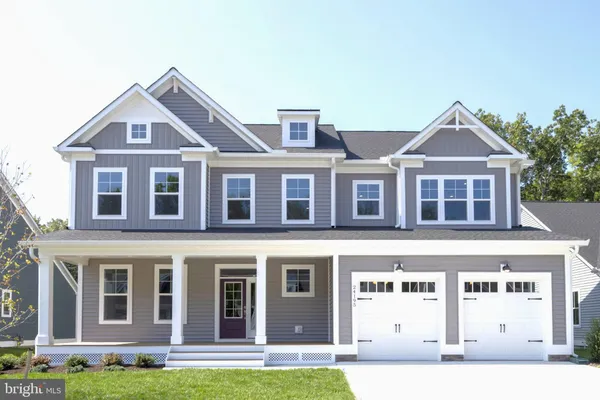 a front view of a house with a yard and trees