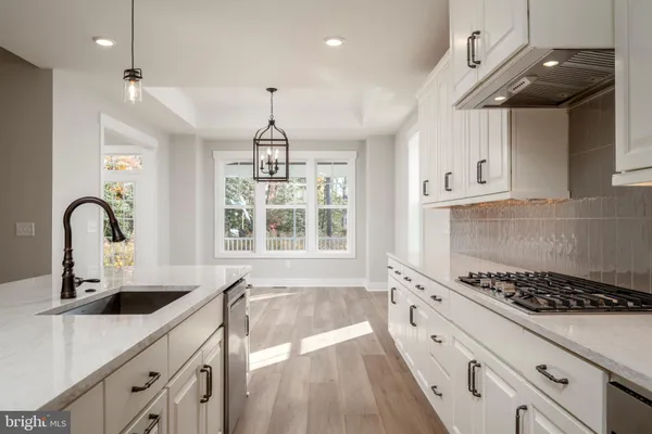 a kitchen with kitchen island granite countertop a sink stainless steel appliances and cabinets