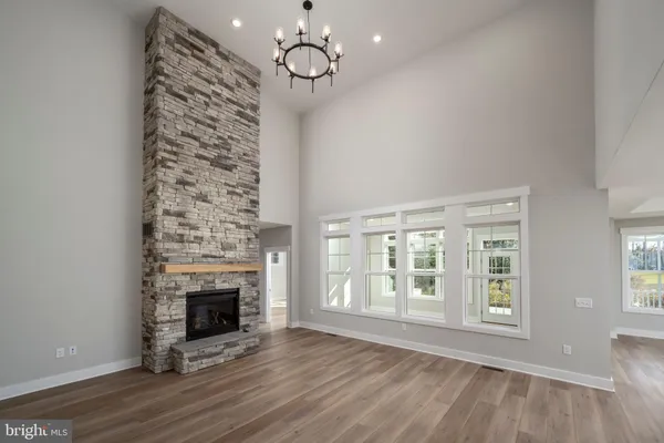 wooden floor fireplace and windows in an empty room