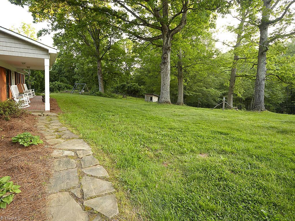 1729 Hauser Road Lewisville, NC 27023 - Photo 16 of 18 Mature oaks offer a beautiful canopy to the front yard. Just to the right is an open fenced area, perfect for a garden.
