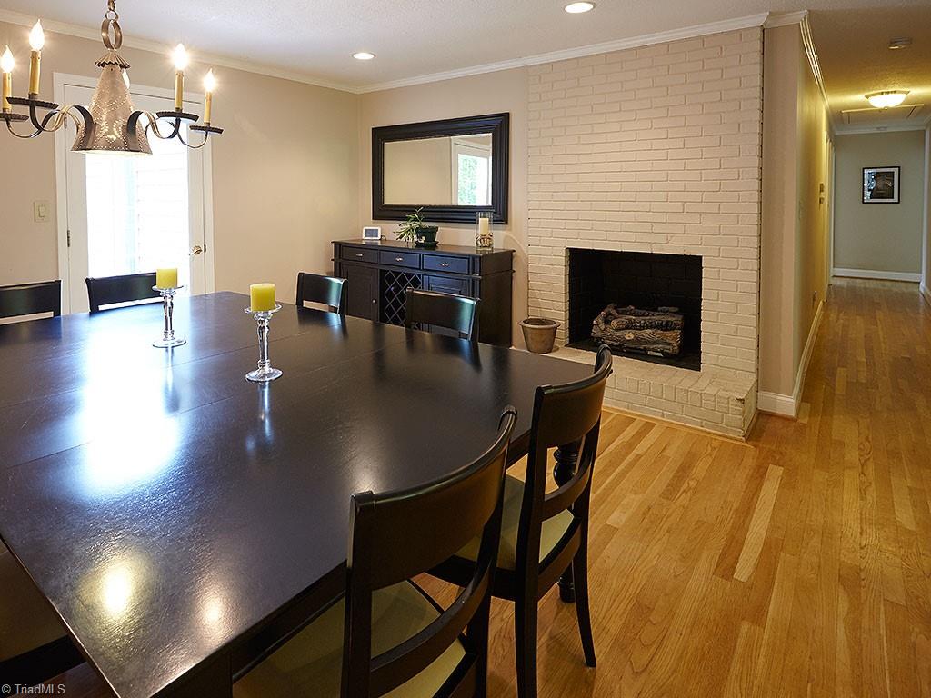 1729 Hauser Road Lewisville, NC 27023 - Photo 6 of 18 Another view of the dining space, featuring the gas log fireplace. Door on the left leads to a large deck. Hallway on the right leads to the bedrooms.