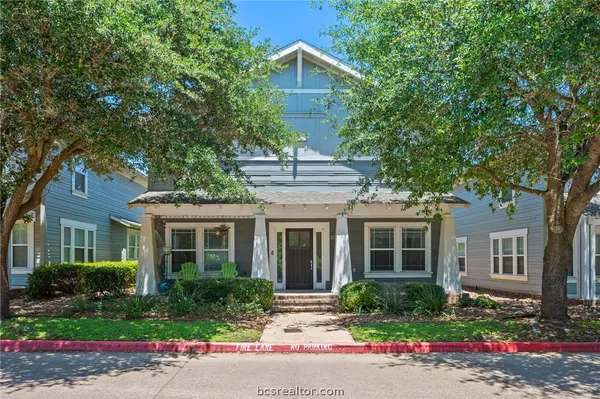 a front view of a house with a yard and potted plants