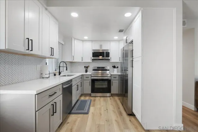 a kitchen with cabinets stainless steel appliances and a counter space