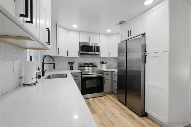 a kitchen with stainless steel appliances a refrigerator sink and microwave