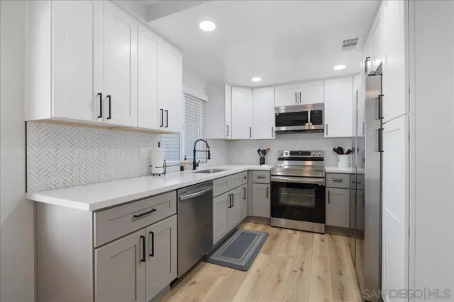 a kitchen with kitchen island a sink a stove and cabinets