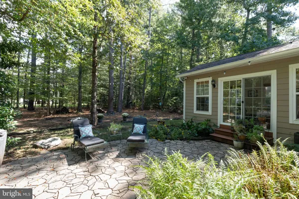 a view of a house with backyard sitting area and garden