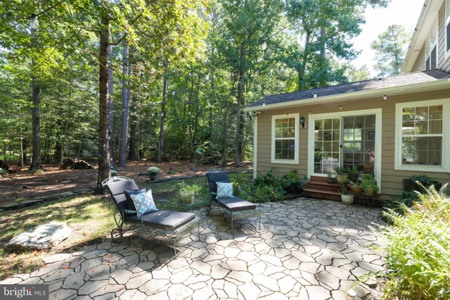 a view of a backyard with sitting area and garden