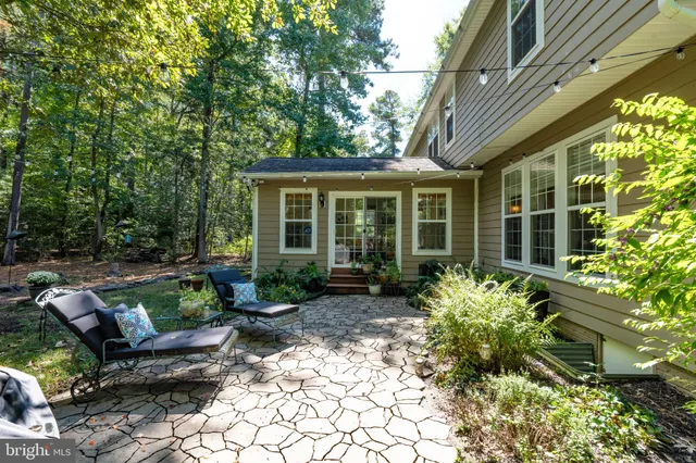 a view of a house with backyard sitting area and garden