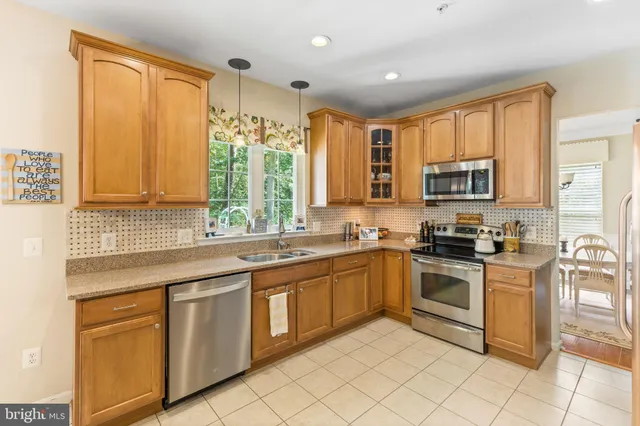 a kitchen with stainless steel appliances granite countertop a stove top oven a sink dishwasher and a refrigerator