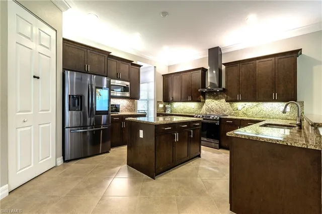 a kitchen with granite countertop a refrigerator stove and sink