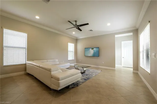 a living room with furniture and a large window with kitchen view