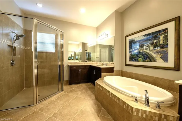 a bathroom with a tub a sink and mirror