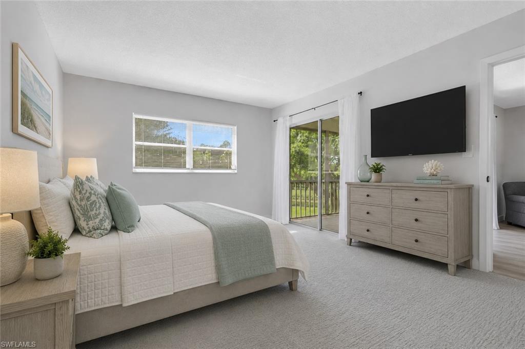 5499 Rattlesnake Hamm Road, Unit A207 Naples, FL 34113 - Photo 12 of 32 a bedroom with a bed and flat screen tv