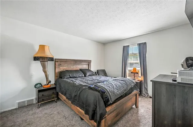 a bed sitting in a bedroom next to a window with a sink