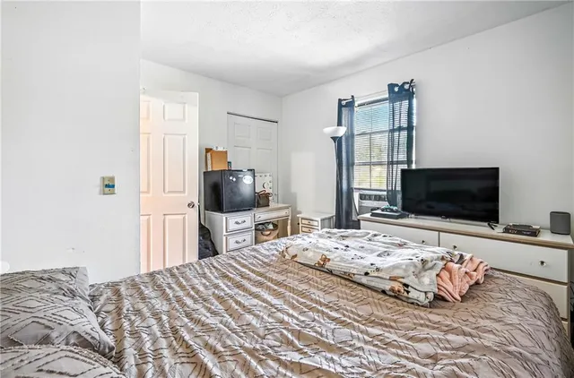 a bedroom with a bed and a flat screen tv