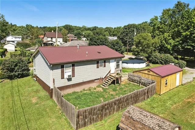 a view of a house with wooden deck and furniture