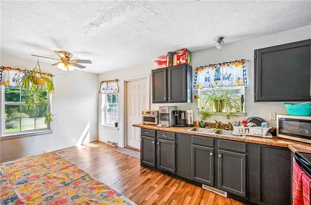 a kitchen that has a lot of cabinets a sink and a window in it