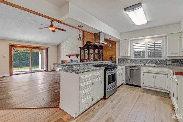 a kitchen with granite countertop stainless steel appliances a stove and a sink