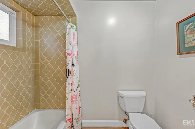 an empty room with ceiling fan and window