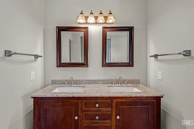 a bathroom with a granite countertop sink and a mirror