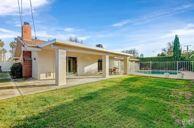a view of house with backyard outdoor seating and barbeque oven
