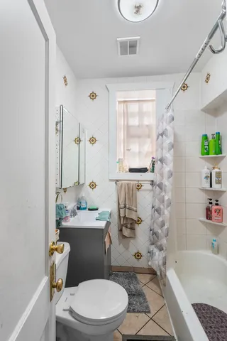 a white toilet sitting next to a bath tub a sink and a shower curtain