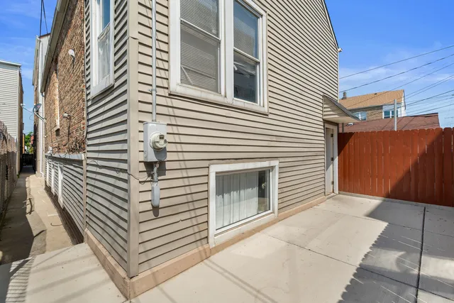 a front view of a residential apartment building with a yard and potted plants