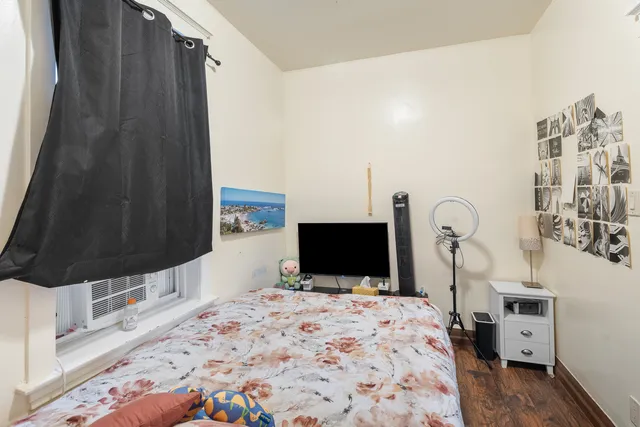 a bedroom with a bed and a flat tv screen on the dresser
