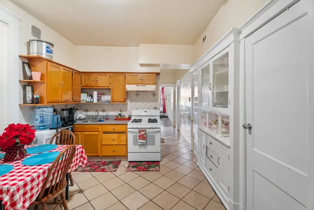 a large kitchen with stainless steel appliances granite countertop a sink and cabinets