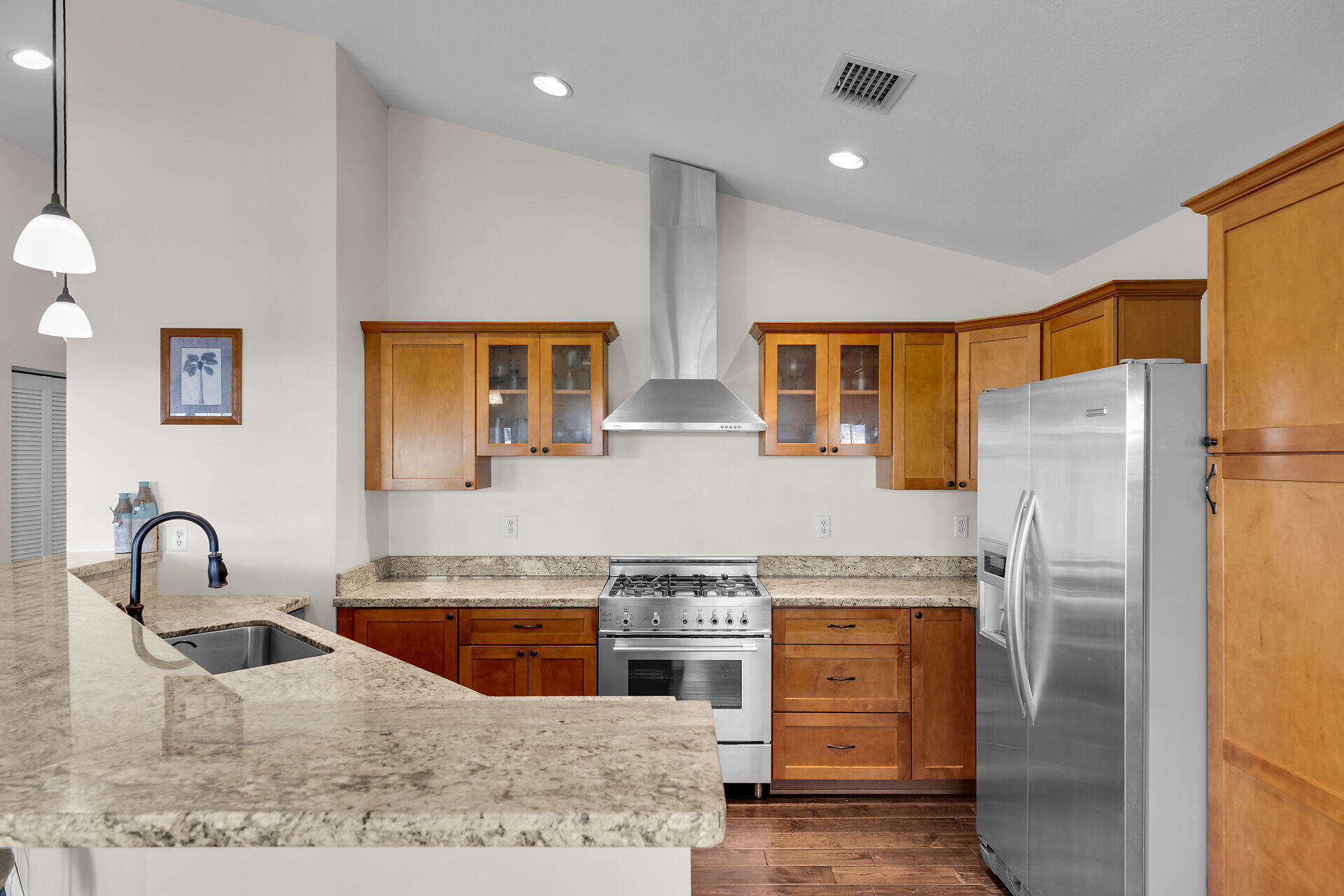 27415 Barbuda Lane Summerland Key, FL 33042 - Photo 10 of 43 a kitchen with stainless steel appliances granite countertop a refrigerator a stove and a sink with wooden cabinets