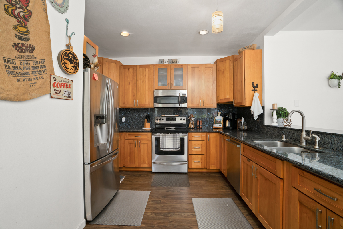 1831 Poipu Road, Unit 113 Koloa, HI 96756 - Photo 6 of 22 a kitchen with granite countertop a refrigerator and a sink