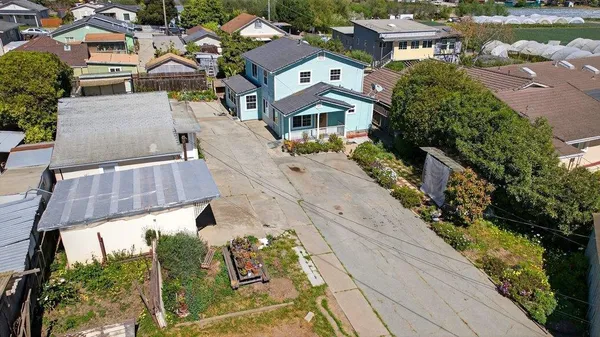 an aerial view of residential houses with outdoor space and swimming pool