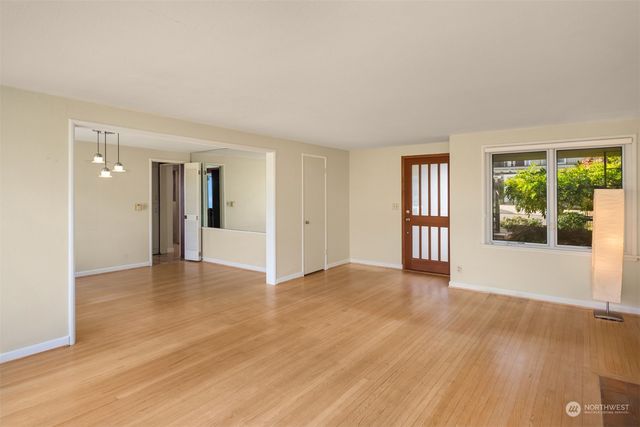a view of an empty room with glass door and wooden floor
