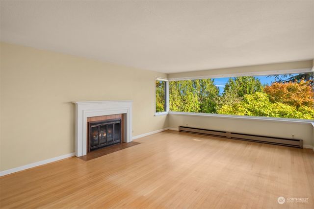 a view of an empty room with a fireplace and a window