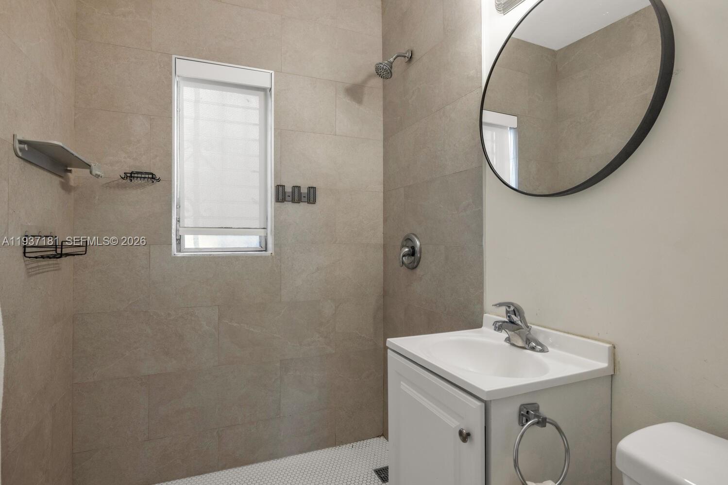 424 Northwest 53rd Street Miami, FL 33127 - Photo 13 of 20 a bathroom with a sink a mirror and a toilet