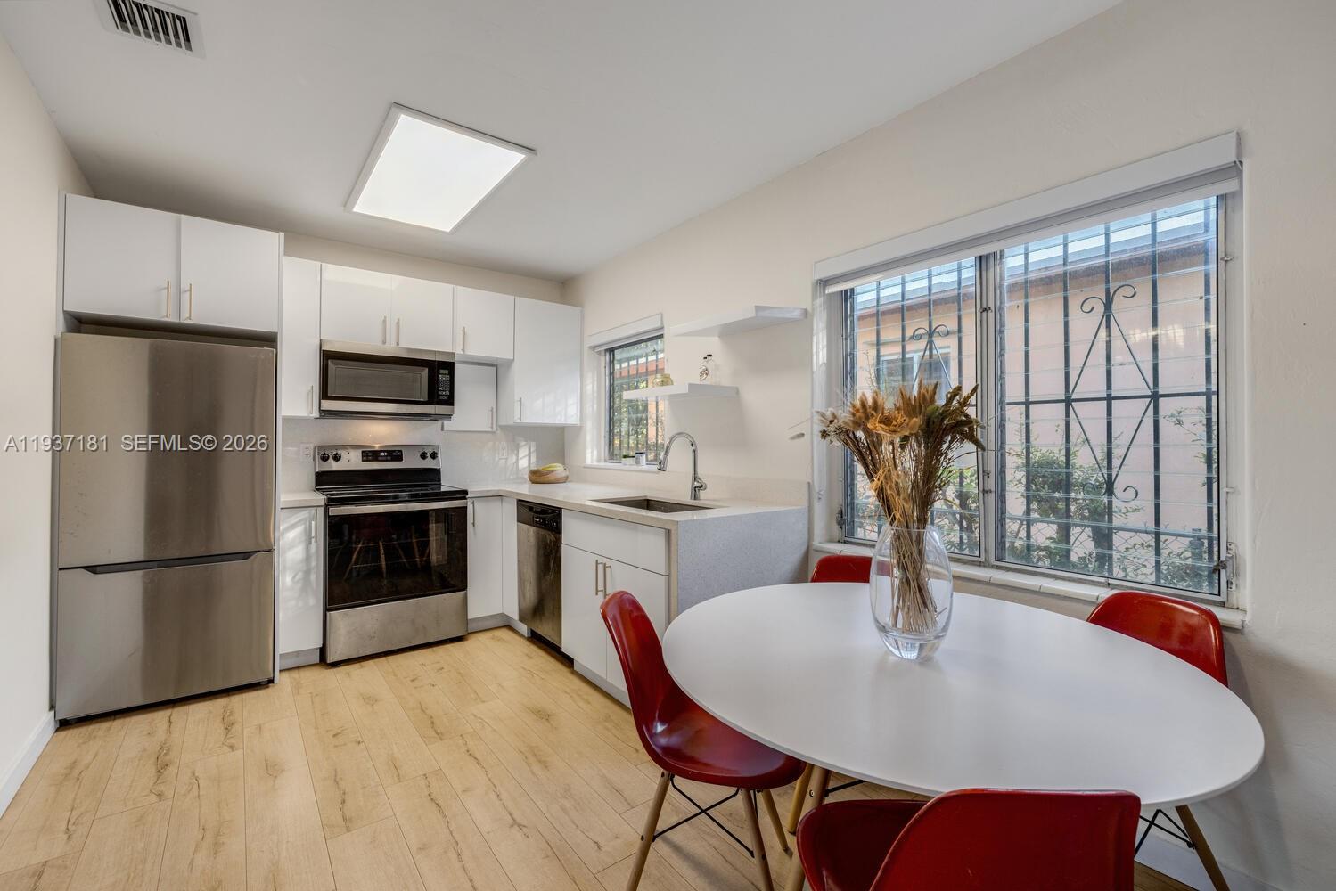 424 Northwest 53rd Street Miami, FL 33127 - Photo 6 of 20 a kitchen with a table chairs stainless steel appliances and cabinets