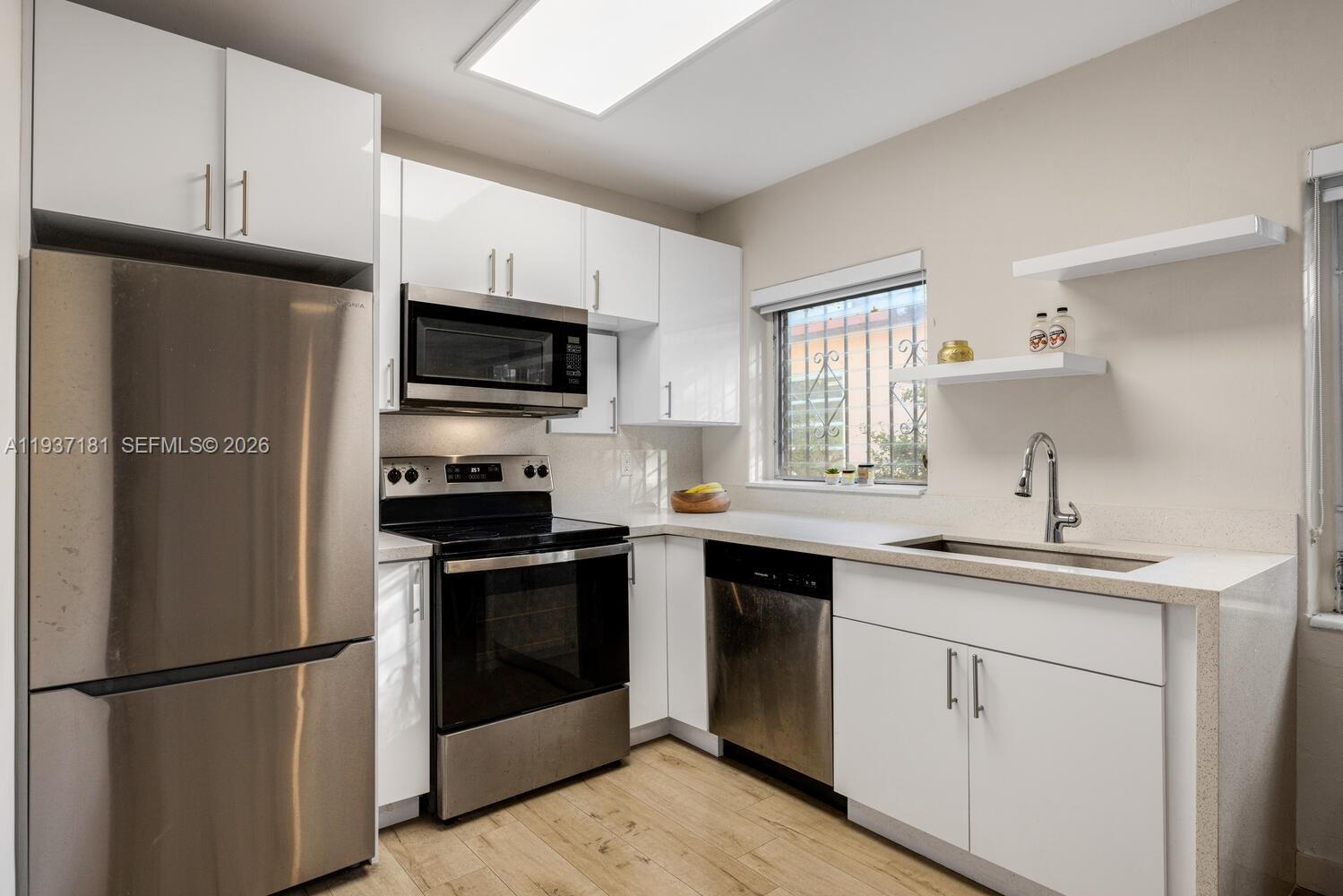 424 Northwest 53rd Street Miami, FL 33127 - Photo 7 of 20 a kitchen with a sink stove and refrigerator